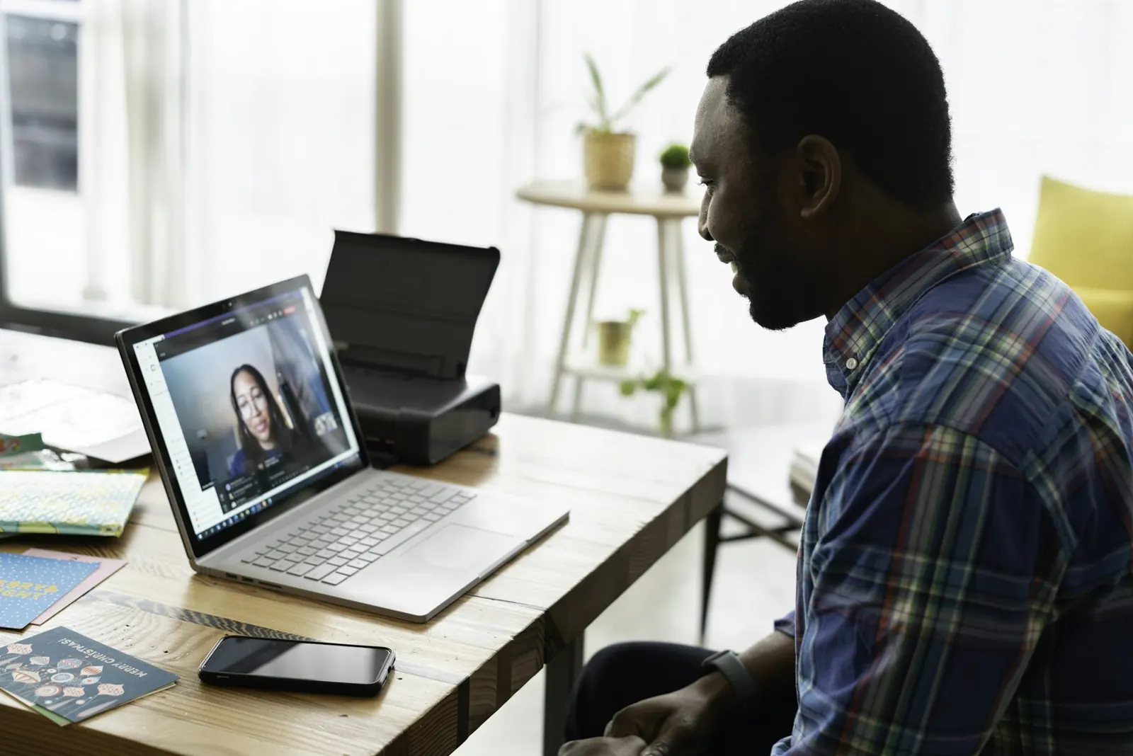Homem em videochamada no notebook, trabalhando de casa
